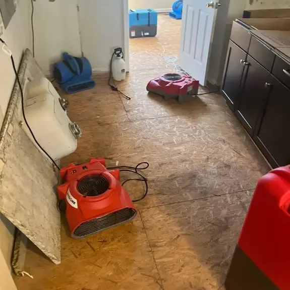 Air movers and a dehumidifier drying a kitchen subfloor