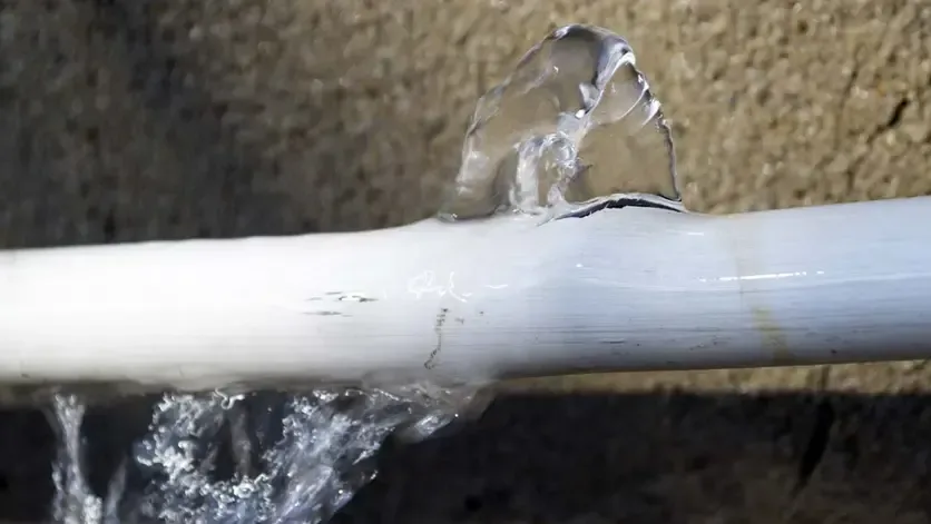 Water spraying from a split plastic supply pipe