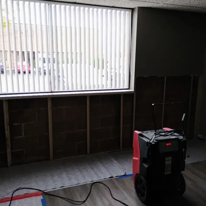 Dehumidifier beside an opened lower wall in a room